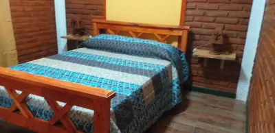 a bedroom with a bed and a wooden bench at Cerros Azules in Trapiche