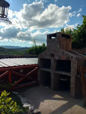 an outdoor brick oven with a view of the mountains at Cerros Azules in Trapiche