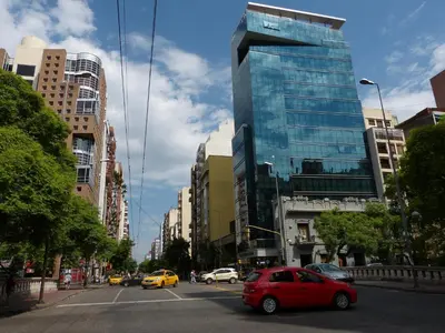 a red car driving down a city street with buildings at Ignea in Cordoba