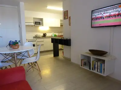 a living room with a table and a kitchen at Ignea in Cordoba