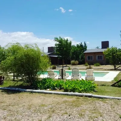 a group of chairs sitting by a swimming pool at Cabañas Hilario in Los Reartes
