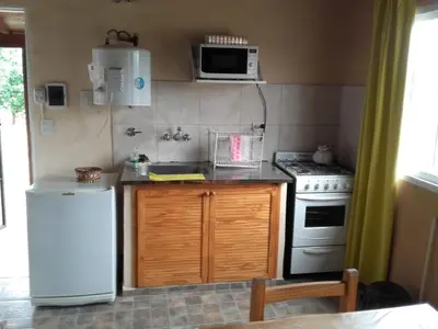 a kitchen with a white refrigerator and a stove at Cabañas Hilario in Los Reartes