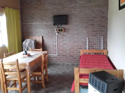 a room with a dining table and a bed at Cabañas Hilario in Los Reartes