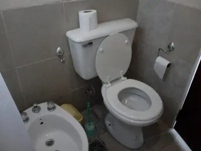 a small bathroom with a toilet and a sink at Cabañas Hilario in Los Reartes
