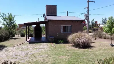 a small brick house with a porch in a yard at Cabañas Hilario in Los Reartes