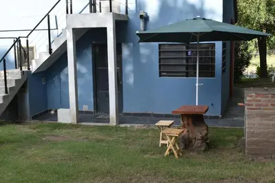 a blue building with a table and an umbrella at siete colores in Santa Rosa de Calamuchita