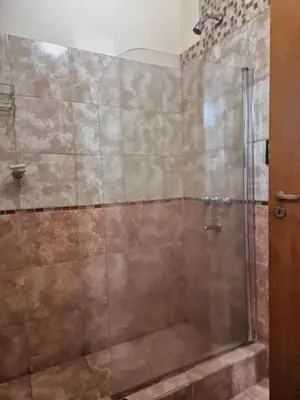 a shower stall with a glass door in a bathroom at siete colores in Santa Rosa de Calamuchita