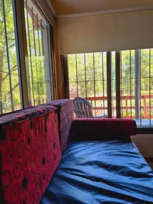 a couch in a room with large windows at siete colores in Santa Rosa de Calamuchita