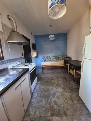 a kitchen with a stove and a couch in a room at siete colores in Santa Rosa de Calamuchita