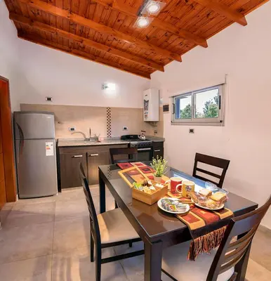 a kitchen and dining room with a table and chairs at Altos del Rio (Solo parejas) in Los Reartes