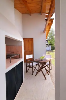 an outdoor kitchen and dining area with a wooden ceiling at Altos del Rio (Solo parejas) in Los Reartes