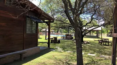 a building with a tree next to a playground at Posada del Tata in Nono