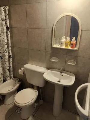 a bathroom with a toilet and a sink and a mirror at Posada del Tata in Nono