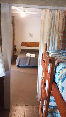 a room with two beds and a bed with a window at Posada del Tata in Nono