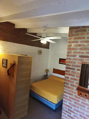 a bedroom with a bed and a ceiling fan at Posada del Tata in Nono