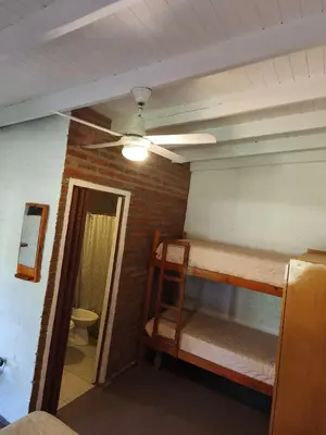 a room with two bunk beds and a toilet at Posada del Tata in Nono