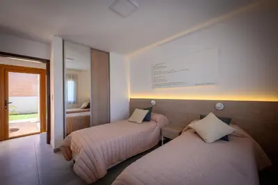 two beds in a hotel room with a window at Casas Acrux in Nono