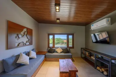 a living room with a blue couch and a tv at Casas Acrux in Nono