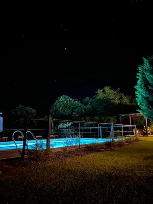 a swimming pool in a park at night at Posada Altos Del Consuelo in Nono