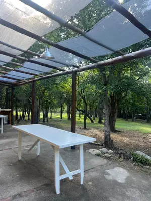 a white picnic table under a canopy in a park at Posada Altos Del Consuelo in Nono