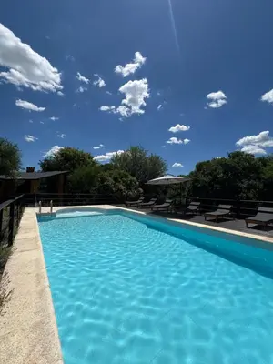 a swimming pool with a blue sky in the background at Posada Altos Del Consuelo in Nono