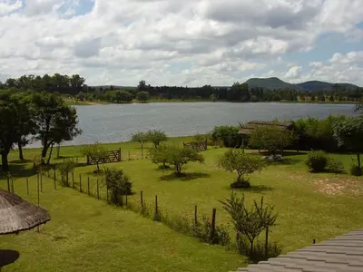 a view of a lake with trees and a fence at Cabañas del Dique Frente al Lago in Villa del Dique