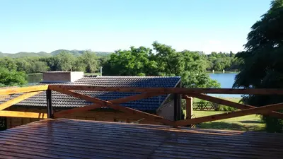 a wooden deck with a view of a body of water at Cabañas del Dique Frente al Lago in Villa del Dique
