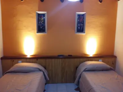 two beds in a room with lights on the wall at 