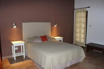 a bedroom with a white bed and two tables at Villa Leandro in Mina Clavero