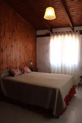 a bedroom with a large bed with a window at Villa Leandro in Mina Clavero