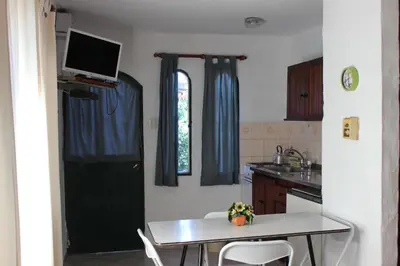 a kitchen with a table and a black door at Villa Leandro in Mina Clavero