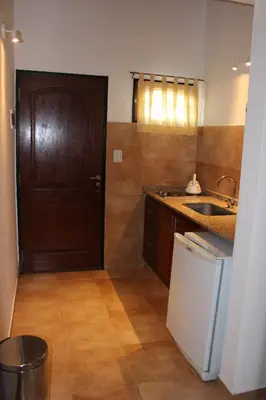 a kitchen with a sink and a counter and a door at Villa Leandro in Mina Clavero