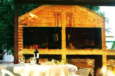 a table with a bottle of wine in front of a fireplace at Villa Leandro in Mina Clavero