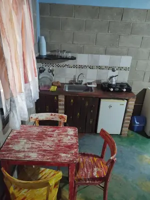 a kitchen with a table and chairs and a sink at Cabañas Don Juan in Mina Clavero