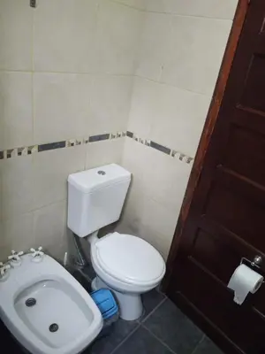 a small bathroom with a toilet and a sink at Cabañas Don Juan in Mina Clavero