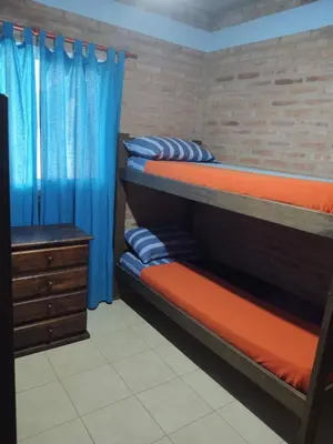 a bedroom with two bunk beds and a dresser at Cabañas Don Juan in Mina Clavero