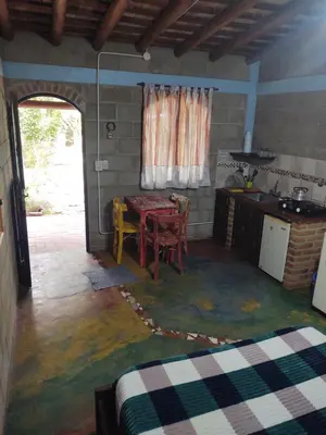 a room with a table and a kitchen with a tableablish at Cabañas Don Juan in Mina Clavero