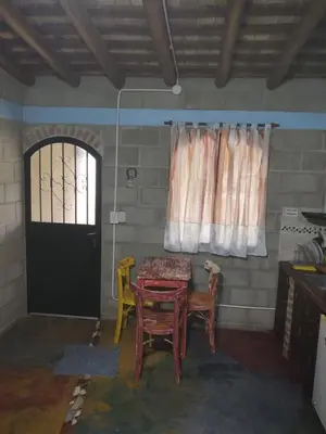 a room with a table and chairs and a door at Cabañas Don Juan in Mina Clavero