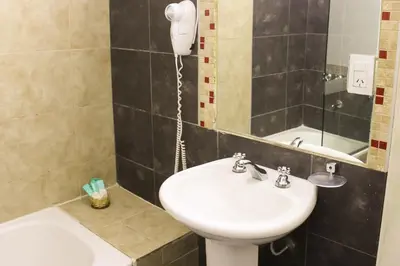 a bathroom with a sink and a mirror at Savannah Cordoba Hotel in Cordoba