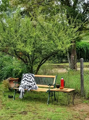 a park bench with a picnic table in the grass at Cabaña Josefina in Los Reartes