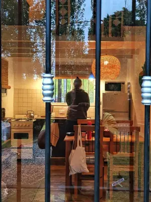 a reflection of a person sitting at a table in a kitchen at Cabaña Josefina in Los Reartes