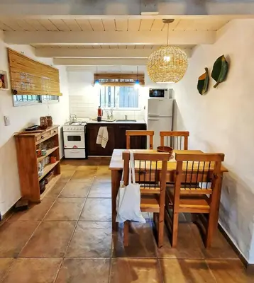 a kitchen with a table and chairs in a room at Cabaña Josefina in Los Reartes
