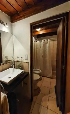 a bathroom with a sink and a toilet and a shower at Cabaña Josefina in Los Reartes