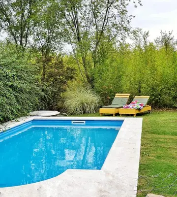 a swimming pool in a yard with two lounge chairs at Cabaña Josefina in Los Reartes