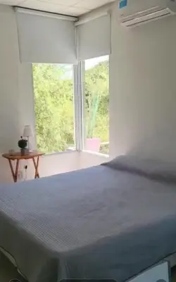 a bedroom with a bed and a large window at Cabañas Don Eduardo in Mina Clavero