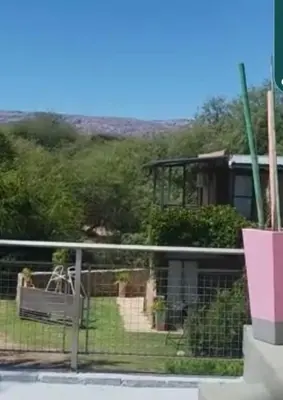 a view of a house with a fence at Cabañas Don Eduardo in Mina Clavero
