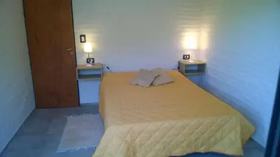 a bedroom with a bed with two lights on the wall at Cabañas Don Eduardo in Mina Clavero