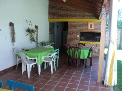 a restaurant with green tables and chairs on a patio at La Nona in Villa Cura Brochero