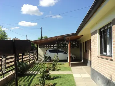 a house with a car parked in the garage at La Nona in Villa Cura Brochero