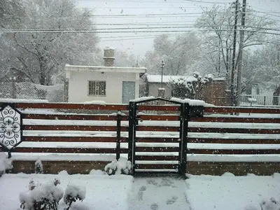 a fence covered in snow in front of a house at La Nona in Villa Cura Brochero